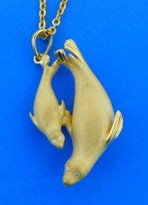 14k yellow gold mother & baby seal pendant, 3d, satin finish on the front, high polish on the back side, brilliant round diamond eyes .03ct twt 30mm long & 7mm thick