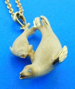 14k yellow gold mother & baby seal pendant, 3d, satin finish on the front, high polish on the back side, brilliant round diamond eyes .03ct twt 30mm long & 7mm thick